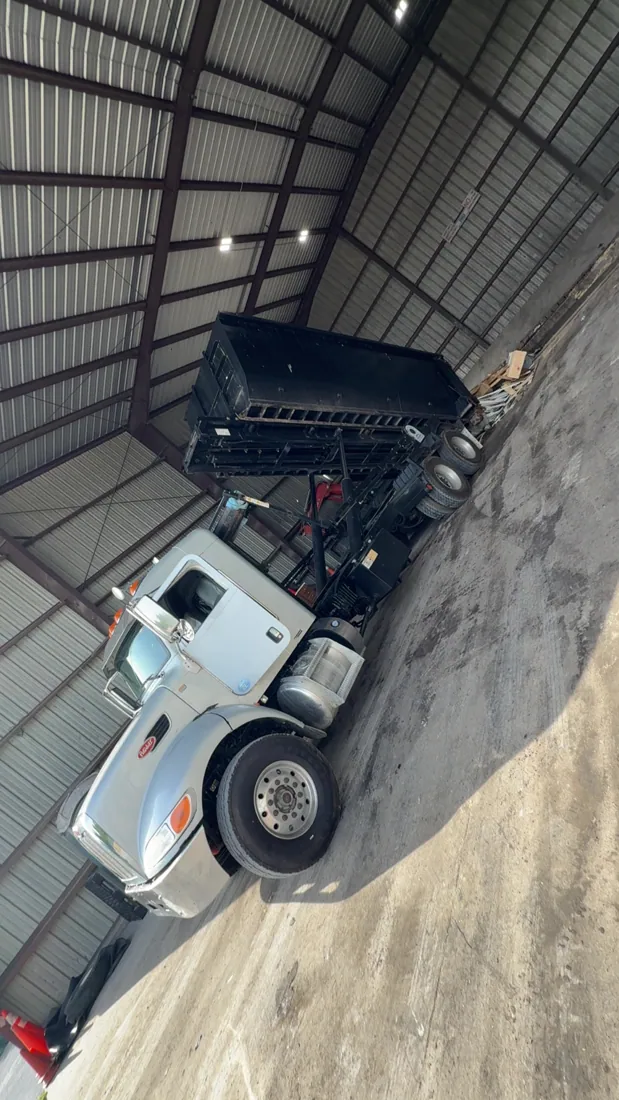 Roll-off container equipment inside a covered garage